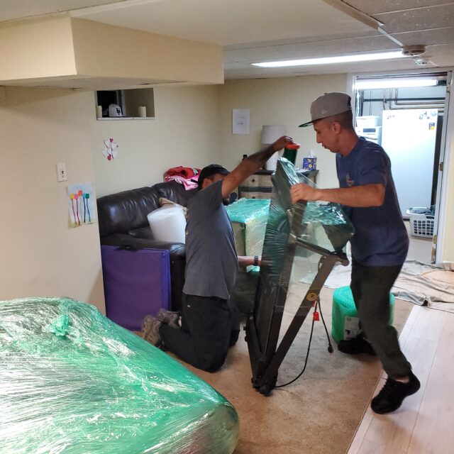 Bright Side Restoration team cleaning up water damaged basement in Massapequa, NY